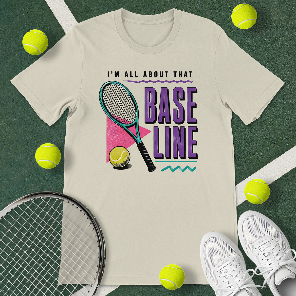 Off-white t-shirt with the text 'I'M ALL ABOUT THAT BASELINE' and a graphic of a tennis racket and tennis ball.