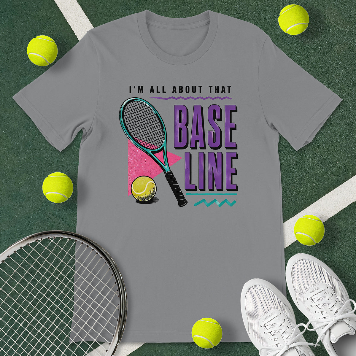 Grey t-shirt with the text 'I'M ALL ABOUT THAT BASELINE' and a graphic of a tennis racket and tennis ball.