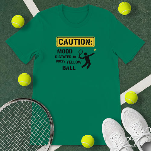 Kelly green t-shirt with the text 'CAUTION: MOOD DICTATED BY FUZZY YELLOW BALL' and a graphic of a person serving.